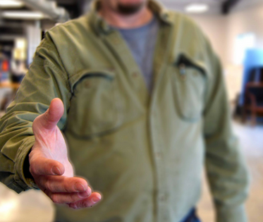 A man holds out his hand in preparation for a handshake.